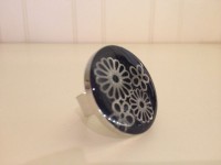 zilverkleurige ring met zwarte achtergrond en bloempatroon